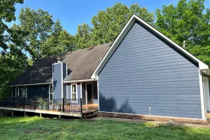 Back of blue vinyl siding house with deck