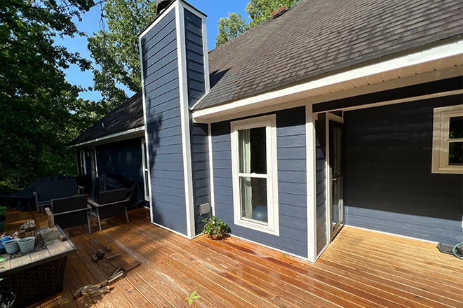 House with blue vinyl siding and a deck