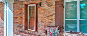 Storm door for house with porch and brick facade