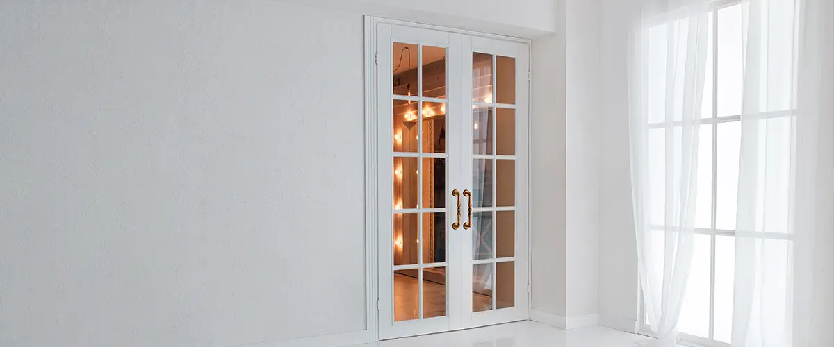 Empty white room with big window and glass french door with bright orange light